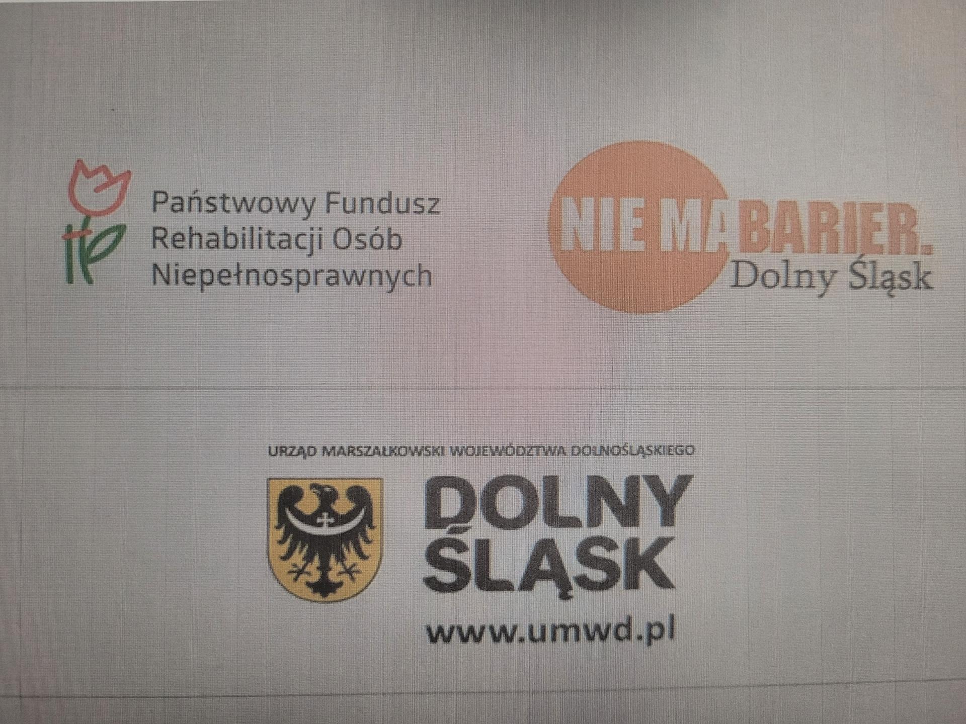Na zdjęciu widać logo Państwowego Funduszu Rehabilitacji osób Niepełnosprawnych ( sygnet przedstawia kwiat, który jest 